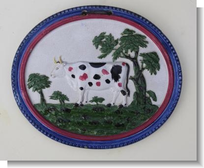 PEARLWARE COW PLAQUE decorated in over glaze colours, c.1820-25